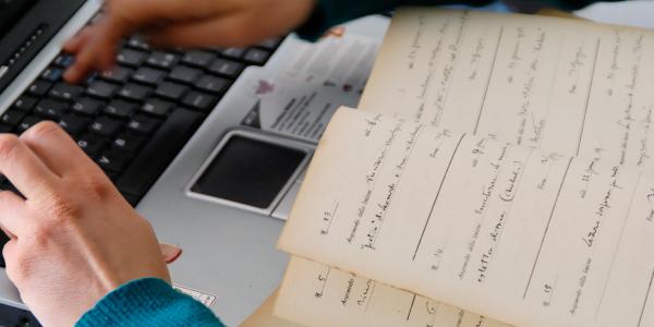 ragazzo al computer con un libro 