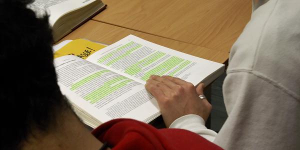 Studente con mano appoggiata su un libro aperto