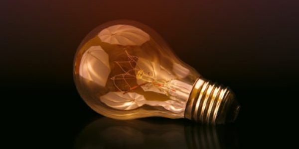 Lampadina a incadescenza accesa su sfondo scuro - Photo by jplenio Johannes Plenio unsplash.com