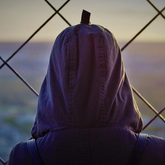 figura umana di spalle davanti a recinzione - Foto tratta da Unsplash