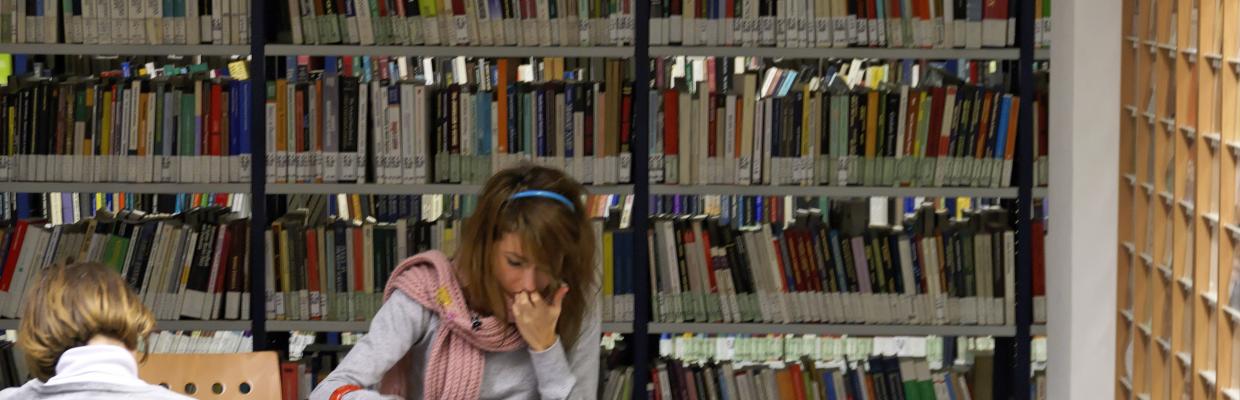 Ragazza che studia in biblioteca